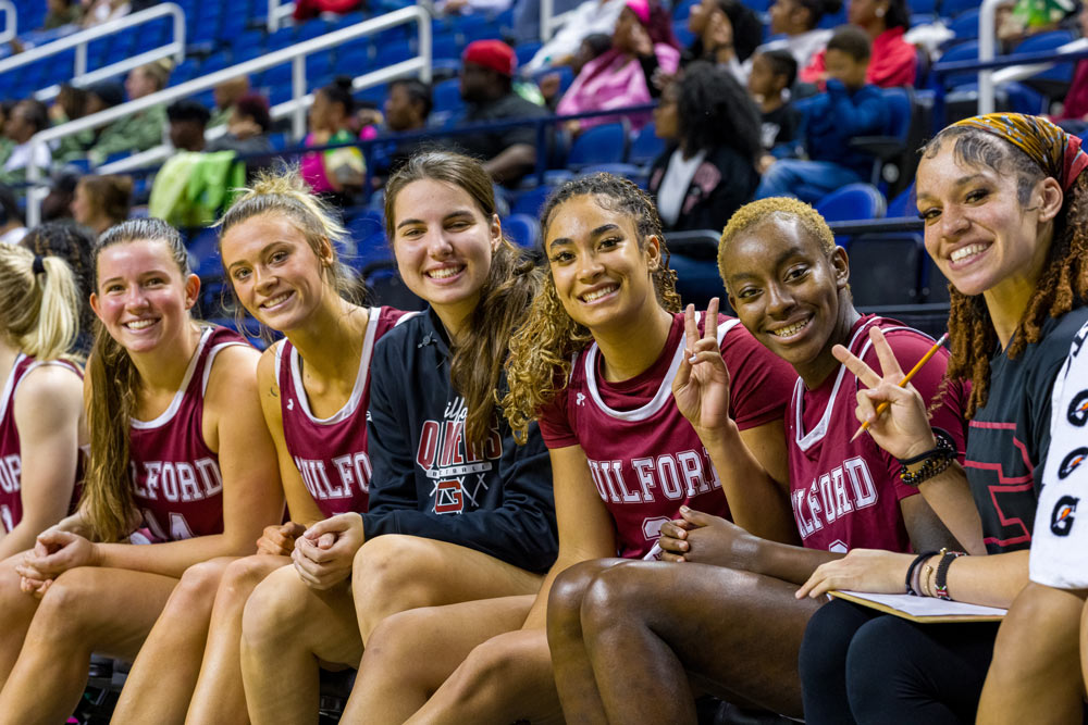 Players on team bench smiling at camera